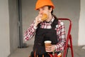 Construction Worker Eating Burger and Drinking Coffee During Lunch Break at Building Site Royalty Free Stock Photo