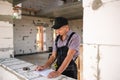 Construction worker engineer at construction site measures the length of window opening and brick wall with tape measure. Man in Royalty Free Stock Photo