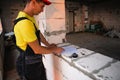 Construction worker engineer at construction site measures the length of window opening and brick wall with tape measure. Man in Royalty Free Stock Photo