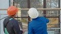 Construction worker and engineer talking at construction site site, rear view. Royalty Free Stock Photo