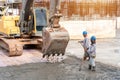 Construction worker with excavator heavy machine for Concrete pouring during commercial concreting floors of building at