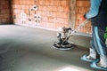 Construction worker finishes concrete screed with power trowel machine Royalty Free Stock Photo