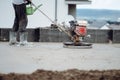 Construction worker finishing concrete screed with power trowel machine, helicopter concrete screed smoothing Royalty Free Stock Photo