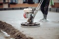 Construction worker finishing concrete screed with power trowel machine. Industrial tools - helicopter concrete screed finishing