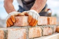 Construction worker with gloved hands carefully laying bricks in a precise arrangement, showcasing craftsmanship and Royalty Free Stock Photo