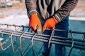 Male construction worker - hands securing steel bars with wire rod for reinforcement of concrete Royalty Free Stock Photo
