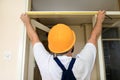 Construction worker and handyman is working on renovation of apartment. Builder is measuring of room door using measure tape. Royalty Free Stock Photo