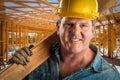Construction Worker in Hard Hat Holding Plank of Wood At Worksite Royalty Free Stock Photo