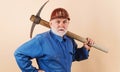 Construction worker in hard hat and uniform with pickaxe. Male laborer with building tools. Royalty Free Stock Photo