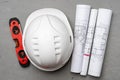 Construction worker hardhat, blueprints and .construction level, top view