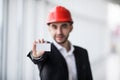 Construction worker holding blank business card in building construction.