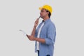 Construction Worker Holding Clipboard in Hands Watching up. Man Thinking. Architect Holding Blueprints. Yellow Hard Helmet Royalty Free Stock Photo