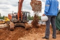 Construction worker holding and excavator