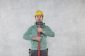 The construction worker is holding a hammer, ready for demolition tasks