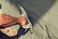 Construction worker holding plastering trowel smoothing wall defects Royalty Free Stock Photo
