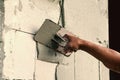 Construction worker holding plastering trowel smoothing wall defects Royalty Free Stock Photo