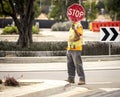 A construction worker holding a stop sign blocking his face Royalty Free Stock Photo