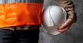 Construction worker holding white hard hat and wearing orange safety vest Royalty Free Stock Photo