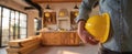 The construction worker holding a yellow hardhat in a modern interior space. AI generated image Royalty Free Stock Photo