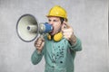 The construction worker holds a megaphone in his hands, the concept of issuing orders