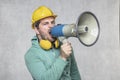 The construction worker holds a megaphone in his hands, the concept of issuing orders