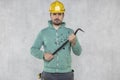 The construction worker holds a work tool in his hands, a crowbar