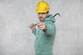 The construction worker holds a work tool in his hands, a crowbar