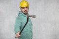 The construction worker holds a work tool in his hands, a crowbar