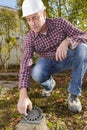 construction worker inspecting water outlet in garden