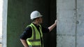 A construction worker inspects the wall of a building on a construction site. Royalty Free Stock Photo