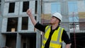 A construction worker inspects the wall of a building on a construction site. Royalty Free Stock Photo