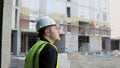 A construction worker inspects the wall of a building on a construction site. Royalty Free Stock Photo