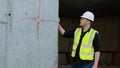 A construction worker inspects the wall of a building on a construction site. Royalty Free Stock Photo