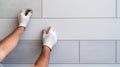 Construction worker installing exterior facade cladding, hands carefully positioning ceramic tiles with precision and professional Royalty Free Stock Photo