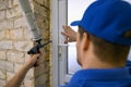 Worker installing new plastic pvc door. mounting the frame with polyurethane foam