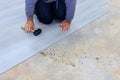 Construction worker installing vinyl laminate flooring in room