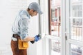 Construction worker installing window in house. Handyman fixing the window with screwdriver Royalty Free Stock Photo