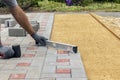 A construction worker installs concrete blocks for sidewalks in the courtyard of a country house Royalty Free Stock Photo
