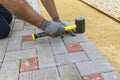 A construction worker installs concrete blocks for sidewalks in the courtyard of a country house Royalty Free Stock Photo