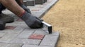 A construction worker installs concrete blocks for sidewalks in the courtyard of a country house Royalty Free Stock Photo