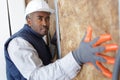 construction worker insulating brick wall with glass wool Royalty Free Stock Photo