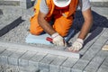 Construction worker on knees leveling paving bricks