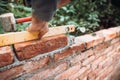 Professional construction worker laying bricks and building walls in industrial site. Detail of hand adjusting bricks Royalty Free Stock Photo