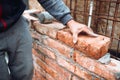 Industrial mason,  construction worker laying bricks and building walls on construction site. Detail of hand adjusting and placing Royalty Free Stock Photo