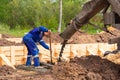 Construction worker laying cement or concrete into the foundation formwork Royalty Free Stock Photo