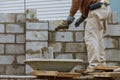 Construction worker laying of concrete blocks bricklaying new house wall