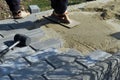 Construction worker are laying concrete pavement stone for footpath work at the construction site. Paving stone worker is putting Royalty Free Stock Photo