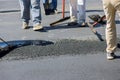 Construction worker laying new asphalt roads as part of a process of asphalting Royalty Free Stock Photo