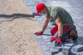 Construction worker laying paving stones on a pathway at a construction site Royalty Free Stock Photo