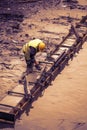 Construction worker leveling concrete formwork